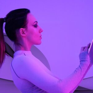 Woman using computer tablet; futuristic neon purple light